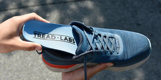 Hand sliding an insole into a shoe