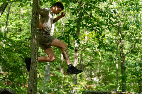 Person jumping through trees in a forest